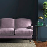 Sofa covered in a purple velvet upholstery fabric