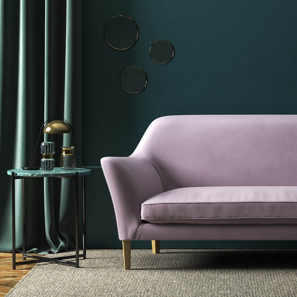 Sofa covered in a purple velvet upholstery fabric 