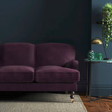 Sofa covered in a purple velvet upholstery fabric