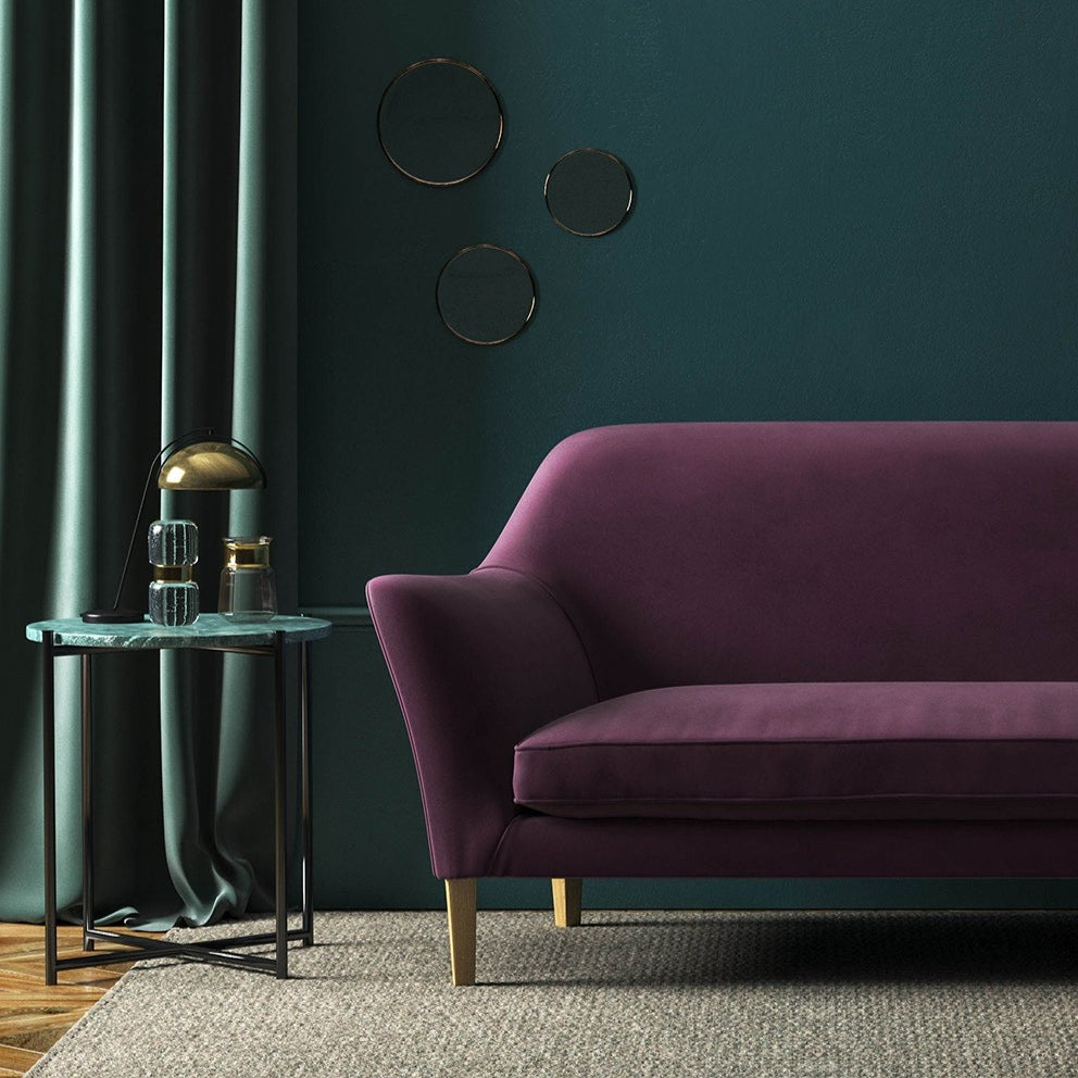 Sofa covered in a purple velvet upholstery fabric 
