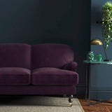 Sofa covered in a purple velvet upholstery fabric