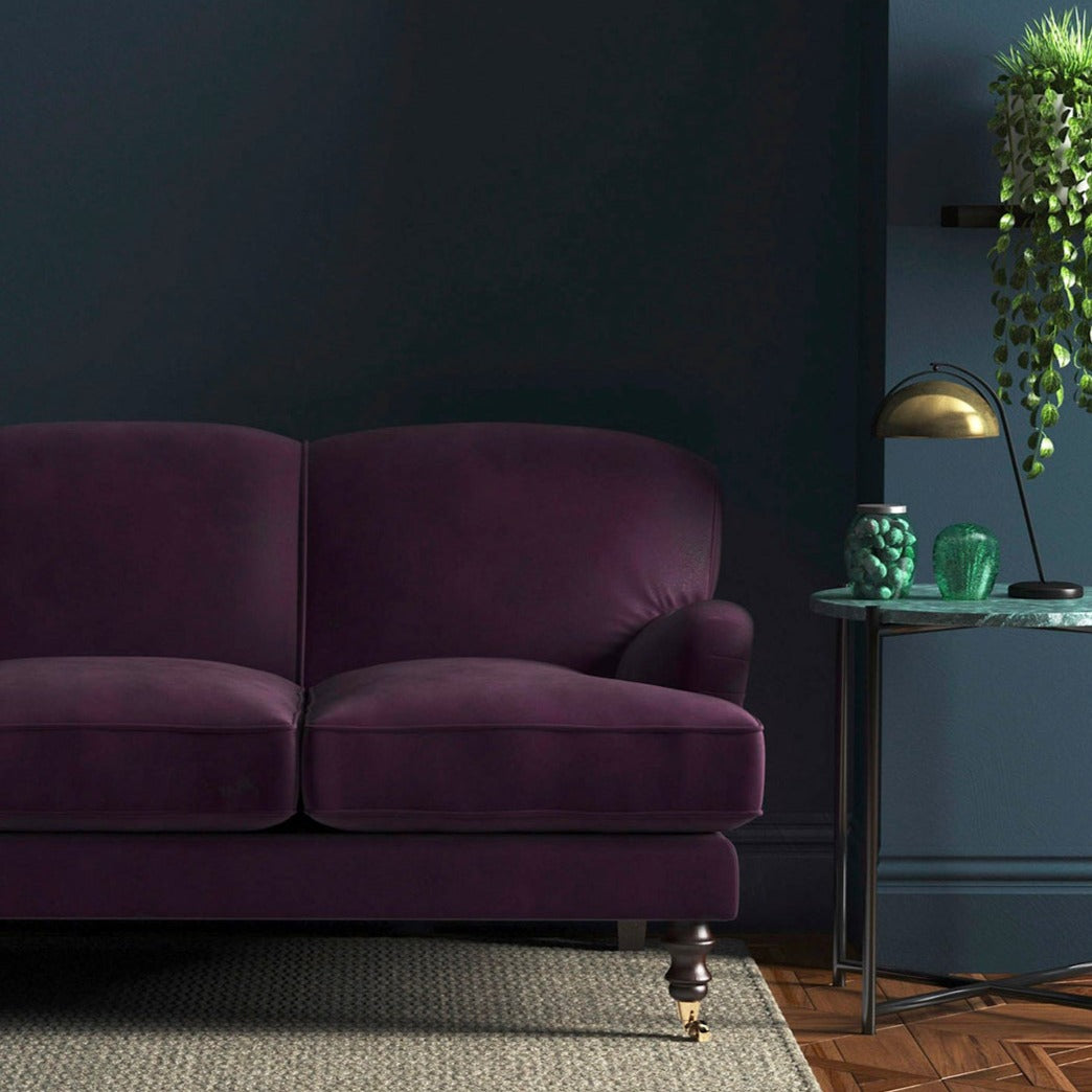 Sofa covered in a purple velvet upholstery fabric