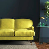 Sofa covered in a yellow velvet upholstery fabric