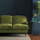 Sofa covered in a green velvet upholstery fabric