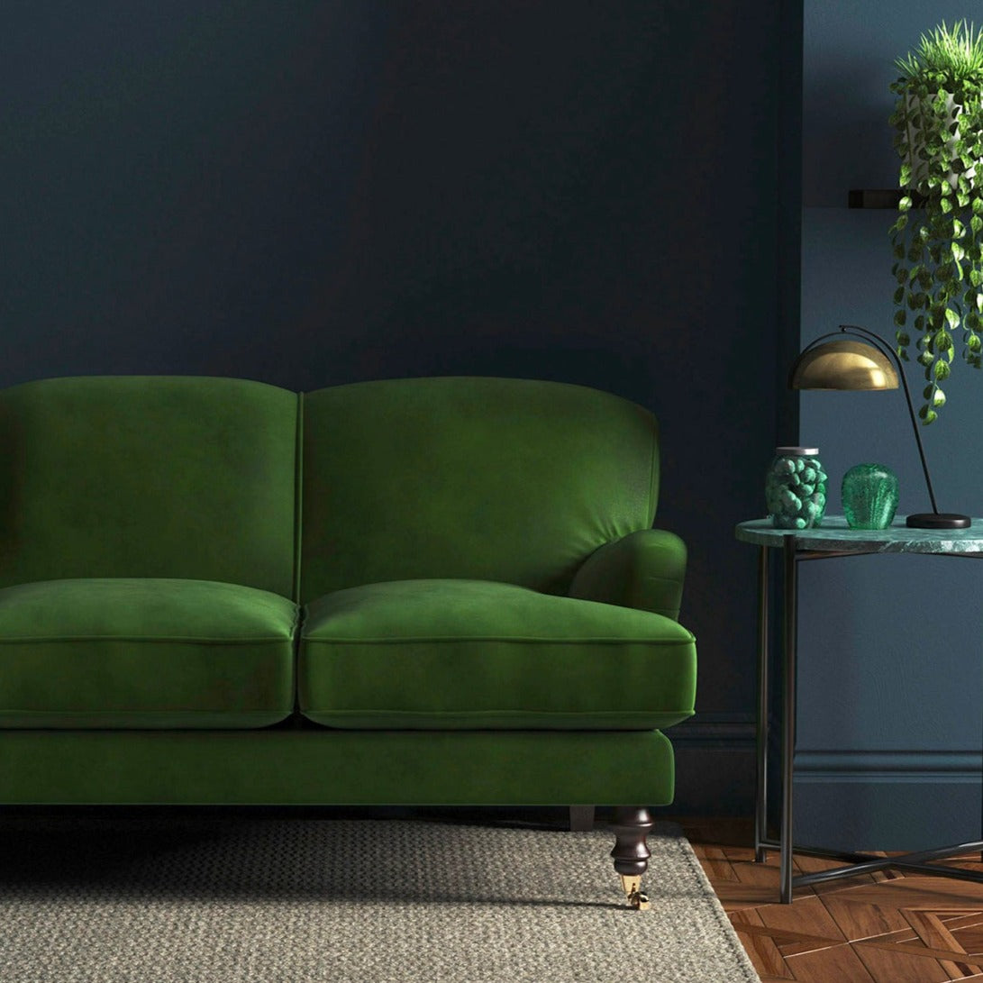 Sofa covered in a green velvet upholstery fabric