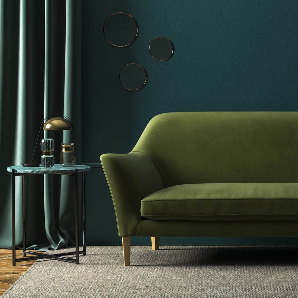 Sofa covered in a green velvet upholstery fabric