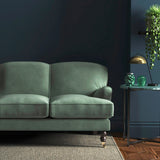 Sofa covered in a blue velvet upholstery fabric