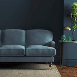 Sofa covered in a blue velvet upholstery fabric