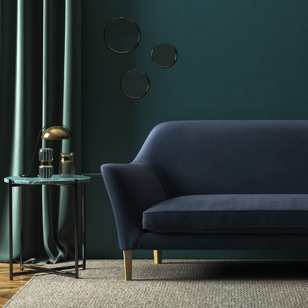Sofa covered in blue velvet upholstery fabric 