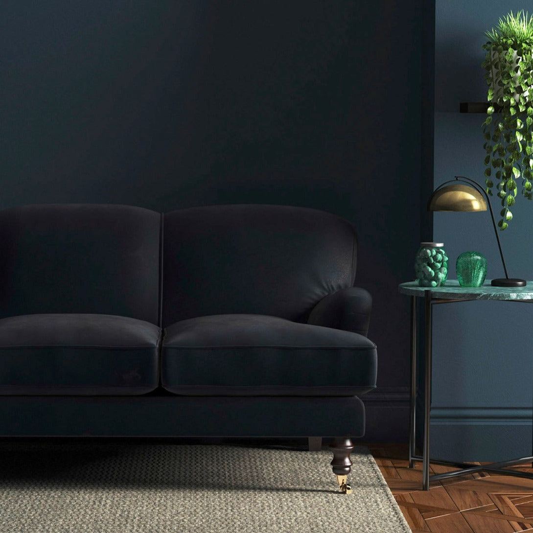 Sofa covered in a blue velvet upholstery fabric