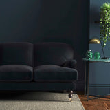 Sofa covered in a blue velvet upholstery fabric