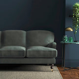 Sofa covered in a blue velvet upholstery fabric