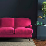 Sofa covered in a pink velvet upholstery fabric