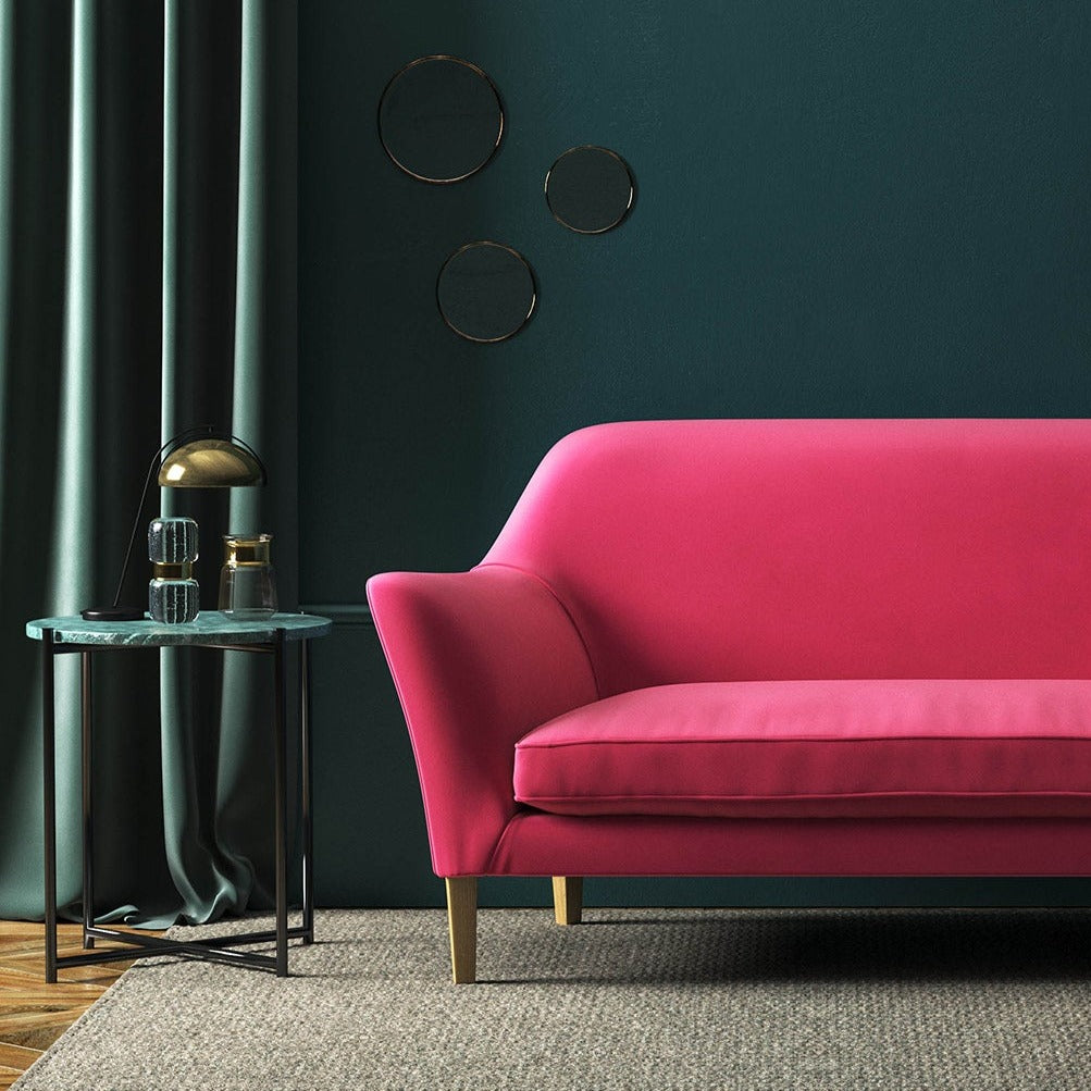 Sofa covered in a pink velvet upholstery fabric 