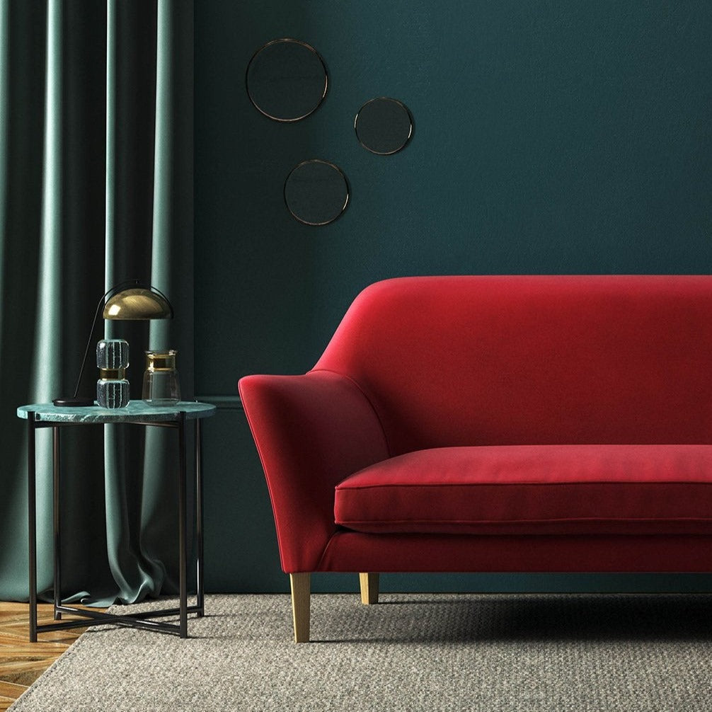 Sofa covered in a red velvet upholstery fabric 