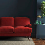 Sofa covered in a red velvet upholstery fabric
