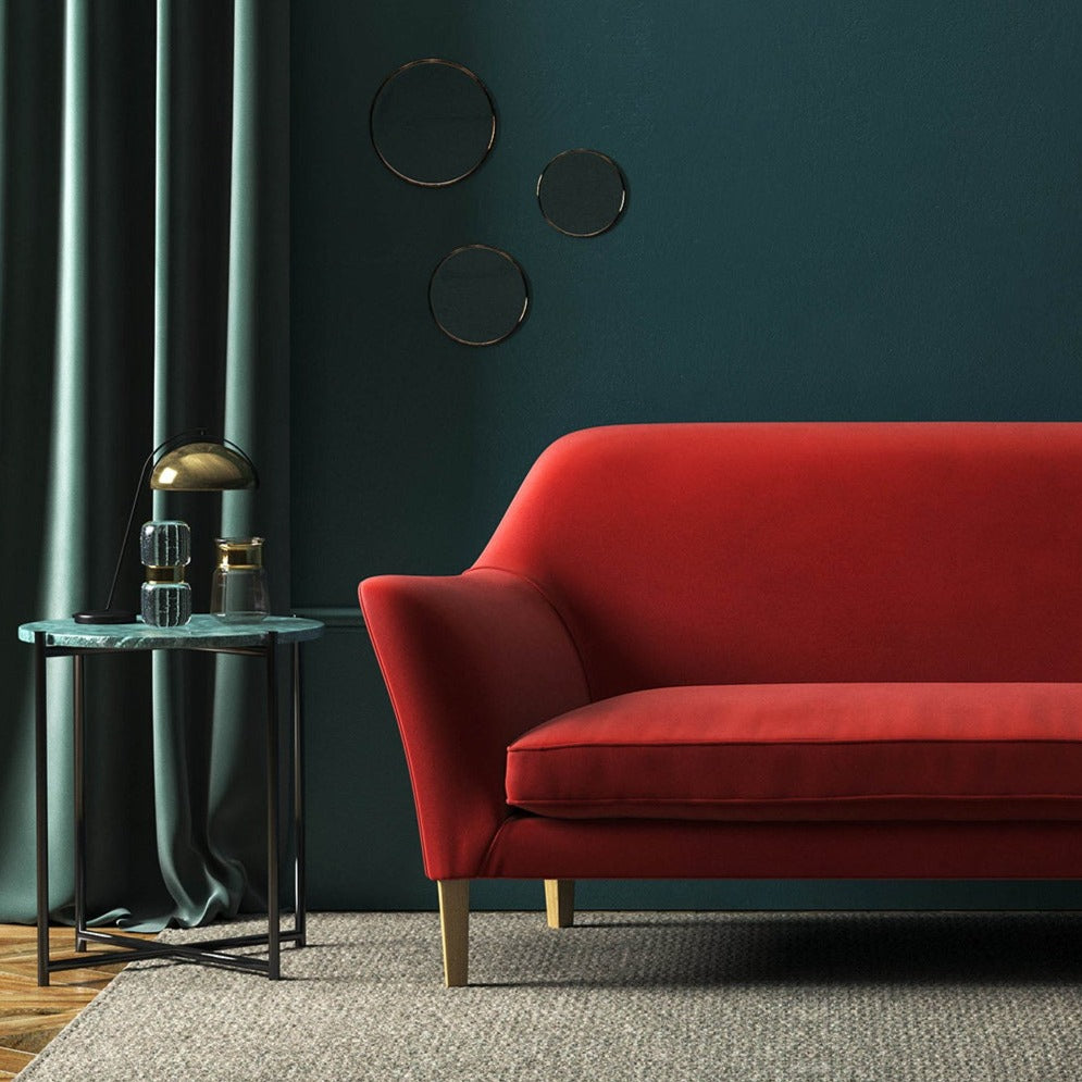 Sofa covered in a red velvet upholstery fabric 