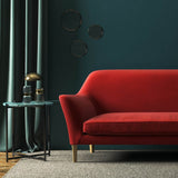 Sofa covered in a red velvet upholstery fabric 