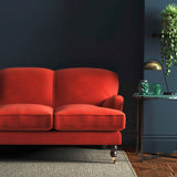 Sofa covered in a orange velvet upholstery fabric