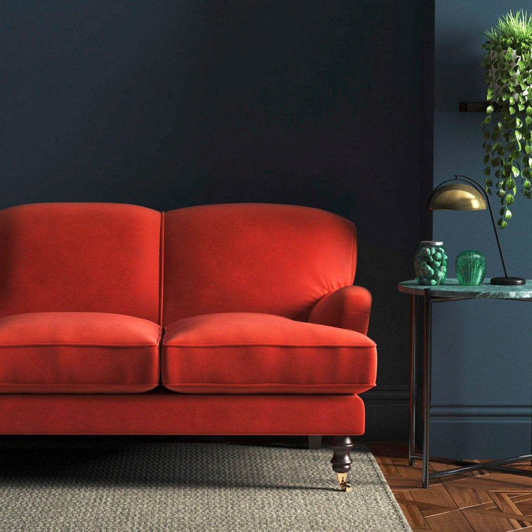 Sofa covered in a orange velvet upholstery fabric