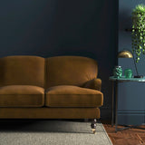 Sofa covered in a brown velvet upholstery fabric