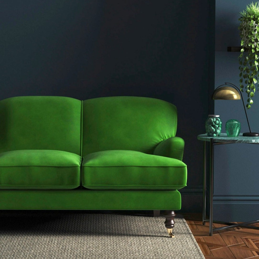 Sofa covered in a green velvet upholstery fabric