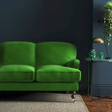 Sofa covered in a green velvet upholstery fabric