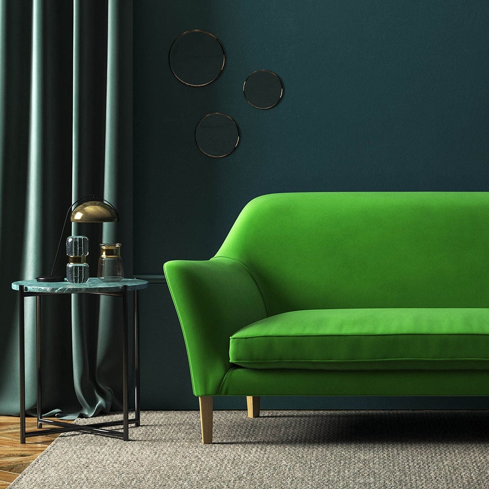 Sofa covered in a green velvet upholstery fabric 