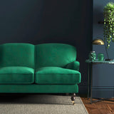 Sofa covered in a green velvet upholstery fabric
