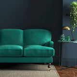 Sofa covered in a blue velvet upholstery fabric