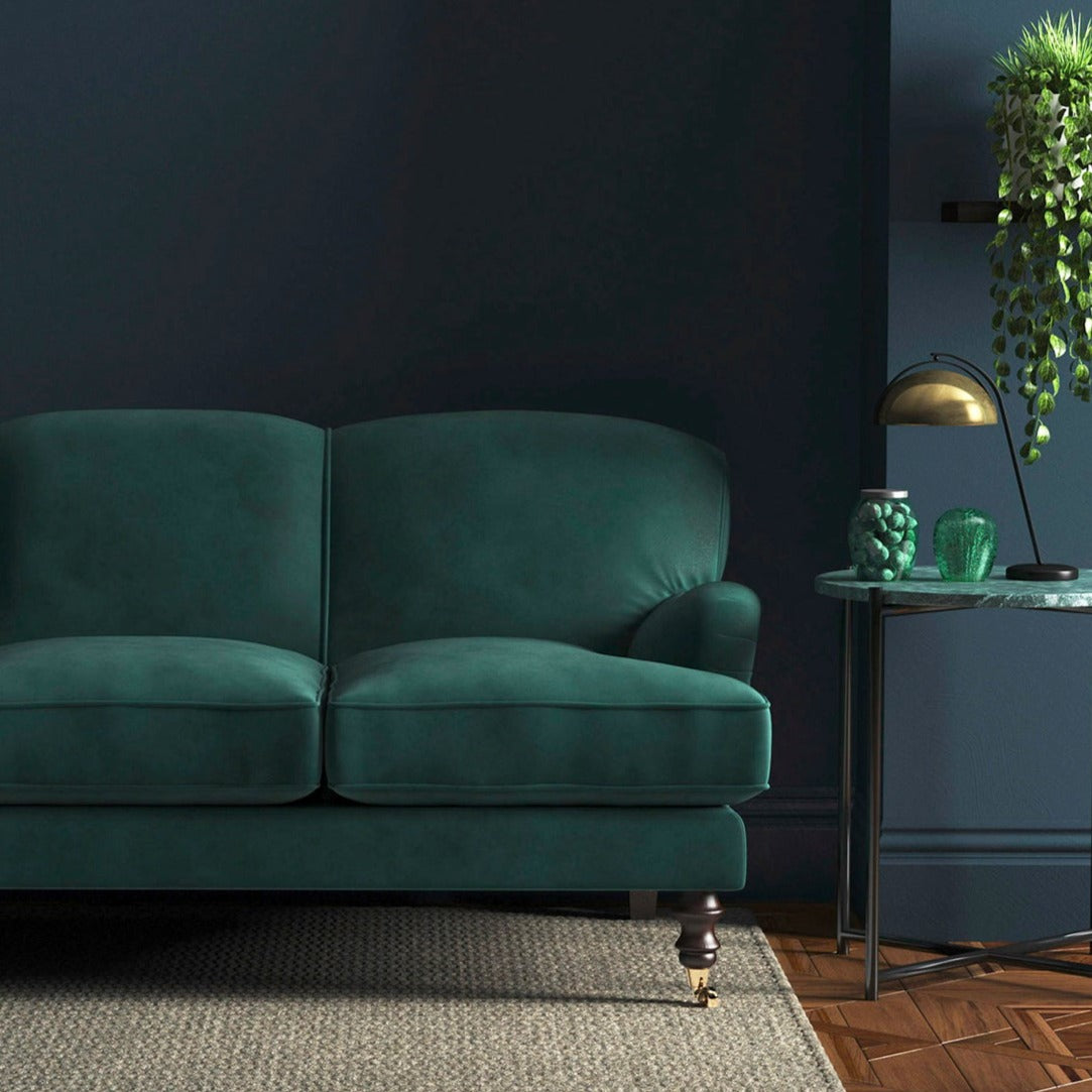 Sofa covered in a blue velvet upholstery fabric