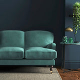 Sofa covered in a blue velvet upholstery fabric
