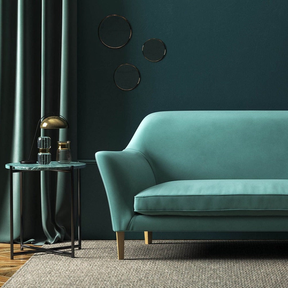 Sofa covered in a blue velvet upholstery fabric 