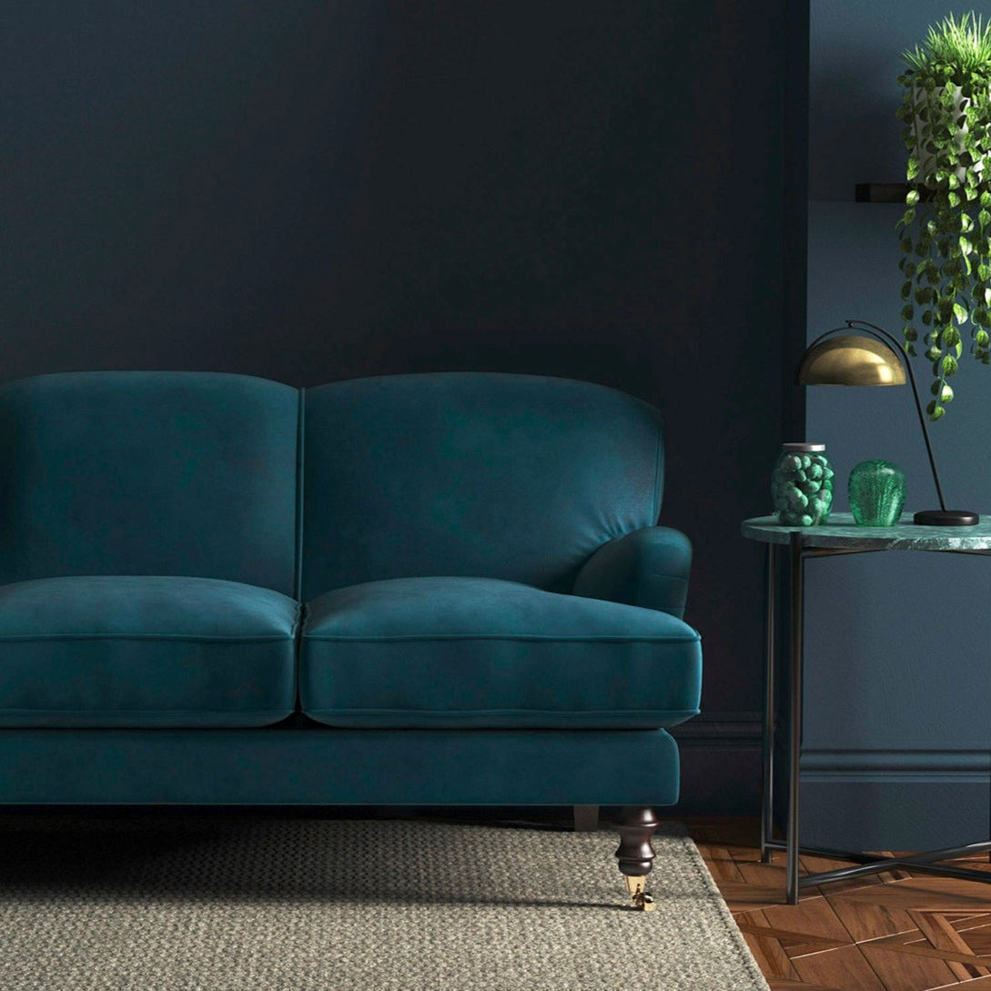 Sofa covered in a blue velvet upholstery fabric