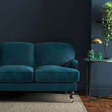 Sofa covered in a blue velvet upholstery fabric