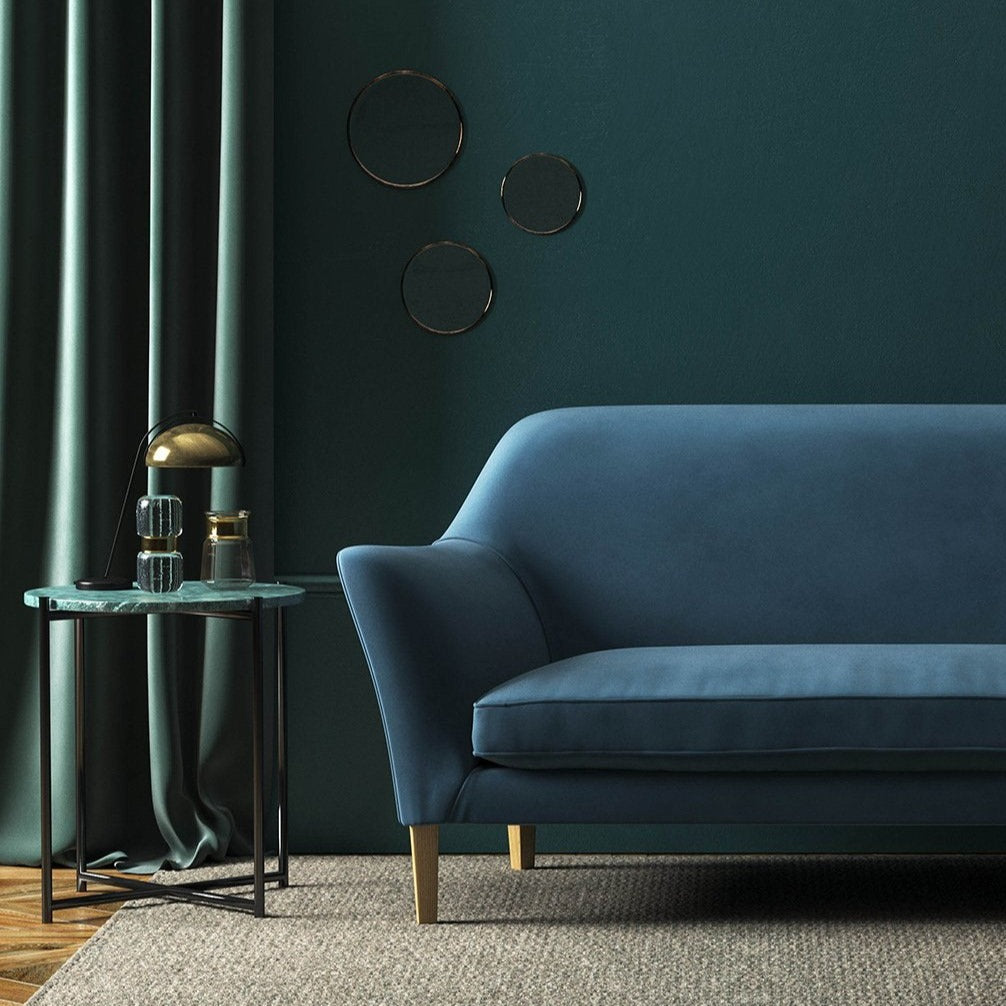 Sofa covered in a blue velvet upholstery fabric