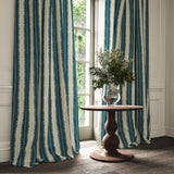 Curtains made from a printed linen fabric in blue and off white, featuring a striped fern design.