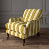 Armchair upholstered in a printed linen fabric in yellow and off white, featuring a striped fern design.