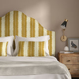 Headboard upholstered in a printed linen fabric in yellow and off white, featuring a striped fern design.