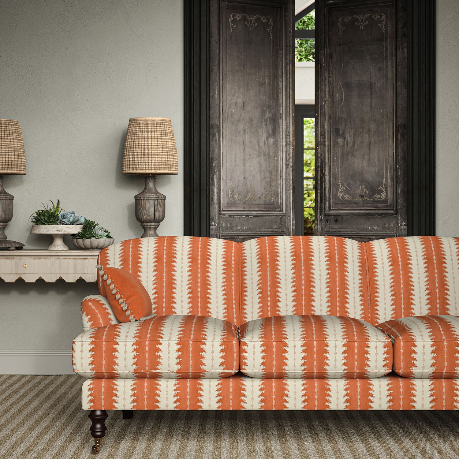 Sofa upholstered in a printed linen fabric in orange and off white, featuring a striped fern design.