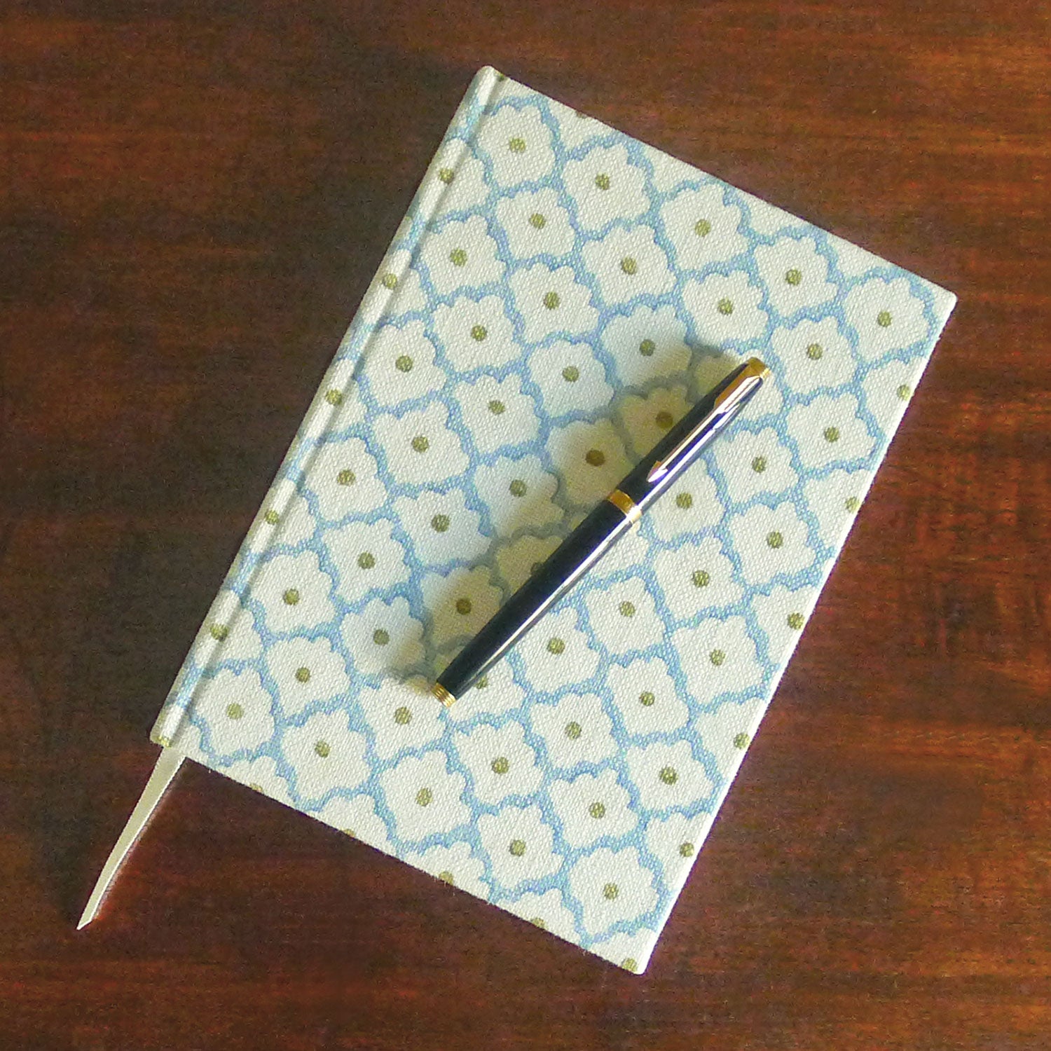 A blue, yellow, cream linen notebook with a classic trellis pattern.